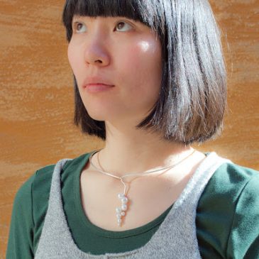 En klase pärlor på silvertråd. A cluster of pearls on silver wire.