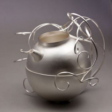 En liten silverkanna. A small silver jug.