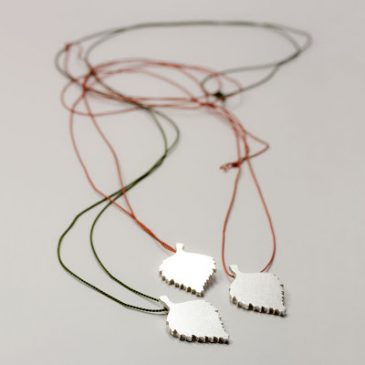 Björkblad i silver med färgad silkestråd. Birch leaves with colored silk cord.