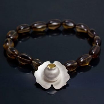 Ett näckrossmycke med rökkvarts collier.  A water lily necklace with smoky quartz beads.