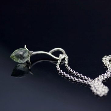 Ett silverhänge, en vattendroppe. A silver pendant, a drop of water.