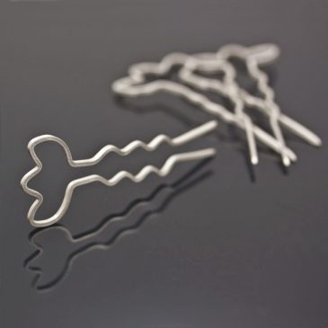 Hårnålar av silver, med moln och blommor.