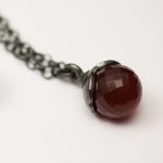 Hängsmycken i form av noppar av fasetterade carneoler och calsidoner med hylle blad av tjockt silver.