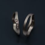 Vigselring och förlovningsring i vitt guld. Fattningen av kaffediamanterna är ett mellanting mellan faden och riven kant.