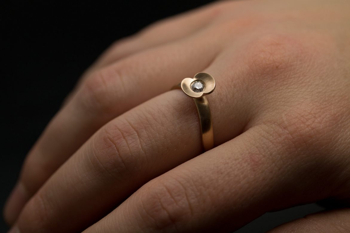 Organisk förlovningsring i 18k rött guld med etisk vit diamant. Skenean är mjukt oval och formad i en båge för att ringen ska få mer form och sitta extra bekvämt på handen.